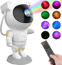 a person holding a remote control in front of a toy astronaut with different colors on it