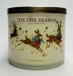 a candle that is sitting on top of a white surface with stars and reindeers