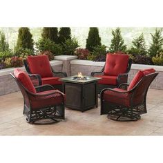 an outdoor conversation set with red cushions and two chairs, on a stone patio area