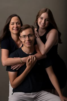 two women and a man are posing for the camera with their arms around each other