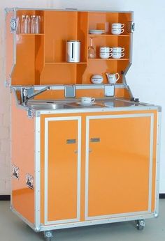 an orange and white kitchen with cupboards on wheels