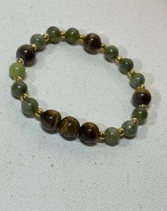 This beautiful handmade bracelet was made with Green aventurine tiger eye quartz beads.  It's the perfect accessory for any occasion whether casual or elegant  Measure are : 6mm  Fits most wrist sizes and has some gentle flexible give to put on and take off easily. Green Aesthetic Bracelets, Green And Brown Bracelets, Brown Bracelet Ideas, Green Beaded Bracelets, Bracelets Ideas, Earthy Outfits, Brown Bracelet, Hazel Eyes, Quartz Beads