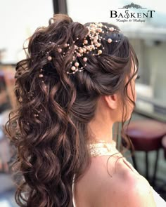 a woman with long curly hair wearing a flowered headpiece and pearls in her hair