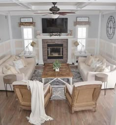 a living room filled with furniture and a flat screen tv mounted on the wall above a fire place