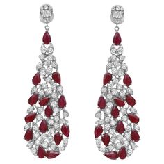 Shimmering ruby and diamonds sway along these stunning 14K white gold women's drop earrings. These earrings feature prong set pear cut rubies and round brilliant cut diamonds encrusted in a pear shaped mounting hanging from a small pear shape stud encrusted with round and baguette cut diamonds. Total diamond weight: 3.37 carats. Diamond quality: color G-H and clarity VS-SI. Total ruby weight: 5.99 carats. Earring length: 2.2 inches. Width: 0.6 inch. Total weight: 15.15 grams. Secured with pushba Luxury Ruby Diamond Earrings For Anniversary, Tear Drop Diamond, Drop Diamond Earrings, Gold Diamond Drop Earrings, Gold Sign, White Gold Chains, Long Drop Earrings, Baguette Cut Diamond, Diamond Drops