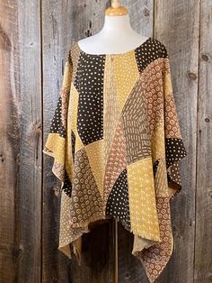 "This poncho is made with a beautiful piece of amber colored Mudcloth. This textile is made with the traditional natural dyes but using modern art style. The handwoven, hand dyed cloth is from Mali. May be styled in either direction. This will fit a size Large to 2X. 49\" W 33\" L There are more on our Etsy site in different patterns to choose from. Each one is unique and one of a kind... DM us for custom orders. Bògòlanfini, or \"Mud cloth,\" is a handmade Malian cotton fabric traditionally dye Bohemian Beige Tunic For Fall, Bohemian Yellow Poncho One Size, Yellow Bohemian One Size Poncho, Yellow Bohemian Poncho One Size, Yellow Bohemian One-size Poncho, Yellow Bohemian Poncho For Fall, Oversized Brown Bohemian Cape, Oversized Bohemian Cape With Batwing Sleeves, Oversized Brown Poncho For Festivals