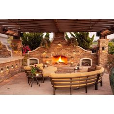 an outdoor fireplace with seating around it