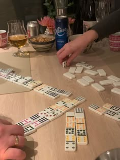 two people are playing dominos on the table