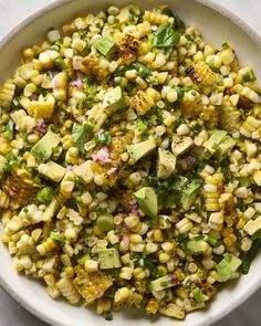 corn salad with avocado and cilantro in a white bowl