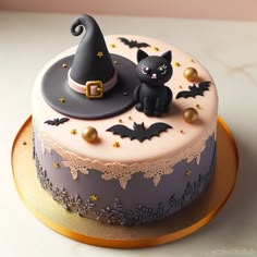 a decorated cake with a cat and witch hat on top