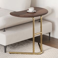 a coffee table with a cup on it in front of a white couch and rug