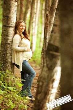 a woman standing in the woods with her arms crossed