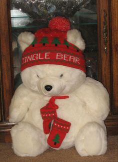 a white teddy bear wearing a red hat and scarf