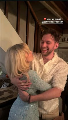 a man is hugging a blonde haired woman