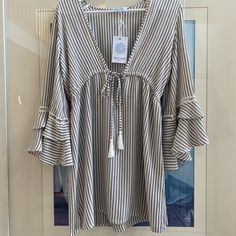 Grey And White Striped With Tie Front And Mid Length Bell Sleeves. 100% Rayon. Size Small, Never Been Worn With Original Tag. Striped V-neck Blouse For Vacation, Casual V-neck Cover-up For Day Out, V-neck Cover-up For Spring/summer Outings, Breezy Spring Vacation Blouse, Breezy Blouse For Spring Vacation, Spring Vacation Breezy Blouse, Beachy Cover-up For Spring Brunch, Casual Vacation Beach Dress For A Day Out, Beachy Spring Brunch Cover-up