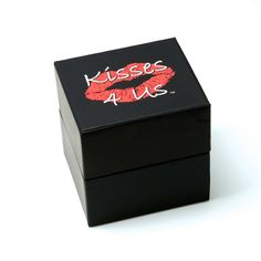 a black box with red lipstick on it that says kiss me and has the words kiss us