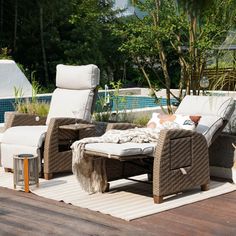 an outdoor lounge area with wicker furniture and pool in the background