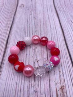 Bubblegum bead bracelet . Mix of 12mm bubble gum beads. Pattern varies with each order. Pink, white, red bubblegum beads,  heart charm.  Disclaimer-contains  small parts. Choking hazard. Not for children under 3. Playful Red Hypoallergenic Jewelry, Cute Heart Beads Beaded Bracelets For Valentine's Day, Cute Heart Beaded Bracelets For Valentine's Day, Personalized Beaded Bracelets For Valentine's Day, Red 8mm Beaded Jewelry For Valentine's Day, Playful Adjustable Bracelet For Valentine's Day, Cute Heart-shaped Beaded Bracelets For Valentine's Day, Pink Charm Bracelet With Round Beads For Gift, Personalized Pink Beaded Bracelets For Valentine's Day