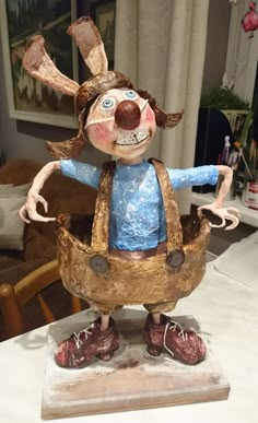 a wooden sculpture of a person with an apron and shoes on top of a table