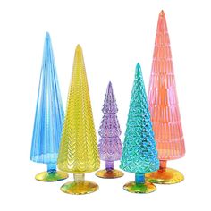 four colorful glass trees are lined up against a white background