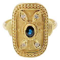 This S.Georgios designer ring is handmade from solid 18 Karat Yellow Gold and is microscopically decorated with Byzantine-style granulation work creating a stunning art piece. This beautiful long ring features an elegant center oval-cut natural Sapphire total weight of 0.19 Carat, framed by petals made of 4 Brilliant cut Natural White Diamonds total weight of 0.06 Carat, and is finished with a unique velvet background. We also make this gorgeous ring in White or Rose Gold, and with different sto Handmade Luxury Gold Sapphire Ring, Byzantine Style Ring With Intricate Design, Byzantine Style Ring Jewelry, Yellow Gold Byzantine Oval Ring, Yellow Gold Oval Byzantine Ring, Handmade Byzantine Oval Rings, Handmade Byzantine Yellow Gold Ring, Unusual Rings Design, Sapphire Hair