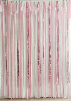 pink and white streamers are hanging from the curtain