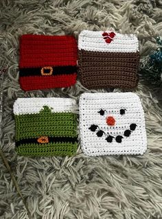 four crocheted christmas coasters sitting on top of a rug