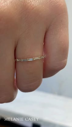 A woman's hand wearing a dainty diamond band. Mixed Metal Band Ring, Stone Band Rings, Hidden Diamond Wedding Band, Simple Birthstone Rings, Eternity Ring Diamond Stack Engagement, Wedding Band Dainty, White Gold And Yellow Gold Wedding Set, Spacer Band Ring, Dainty 3 Stone Engagement Ring