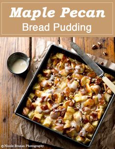 an apple pecan bread pudding in a baking pan on a wooden table with a spoon