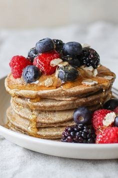 a stack of pancakes topped with berries and blueberries