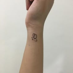 a woman's wrist with a small tattoo on it