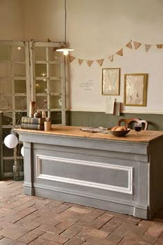 an old fashioned desk in the corner of a room with pictures hanging on the wall