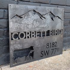 a metal sign on the side of a building that says corbbett bird