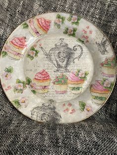 a plate with cupcakes on it is sitting on a piece of fabric,