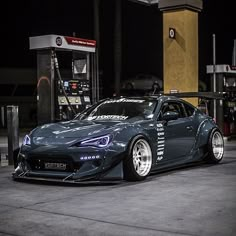 a car parked in front of a gas station at night