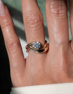 a woman's hand with a ring on it and a diamond in the middle