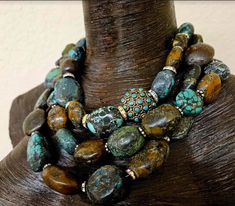 This multiple strand Hubei Turquoise boulder statement necklace has all the wow factor you have come to expect from Kat Kouture! This bold, chunky and heavy piece is actually a unisex design so men are welcome to it, also! Three strands of Hubei turquoise are space with either gold tone metal daisies or rhinestone rondelles. There is one inlaid turquoise brass bead from Tibet which serves as an accent and adds additional interest and drama. This piece adjusts from 17-20" and closes with an XL fa Luxury Ceremonial Jewelry With Large Beads, Artisan Turquoise Stone Necklace, Artisan Turquoise Necklace, Chunky Necklaces Statement, Egg Baked, Jewelry Queen, Gaudy Jewelry, Rocker Chic Accessories, Agate Necklaces