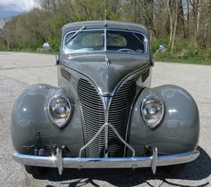 an antique car is parked on the side of the road