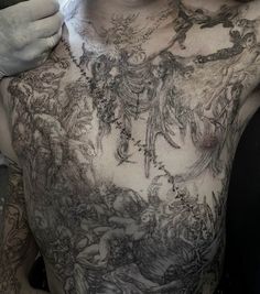 a man with tattoos on his chest and hands