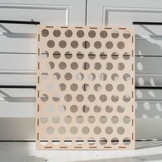 a wooden board with holes on it sitting in front of a garage door