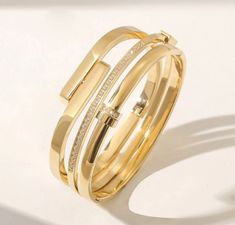 Durable and stylish, our waterproof bracelet is crafted for both functionality and fashion. Perfect for any occasion, it's the ideal accessory for those who appreciate durability and timeless elegance. Perfect for the minimalist and a beautiful piece to layer with. - 18K gold plated / stainless steel - Waterproof technology - Bangle opens and measures 50mm inner diameter. - 5mm in width. Adjustable Luxury Bangle For Everyday, Modern Everyday Luxury Gold Plated Bracelet, Modern Everyday Luxury Gold-plated Bracelet, Adjustable Gold Bangle For Everyday Luxury, Adjustable Gold Cuff Bracelet For Everyday Luxury, Luxury Gold Plated Tarnish Resistant Bangle, Chic Gold Bracelet For Everyday Luxury, Chic Gold Bracelet For Everyday Wear, Chic Everyday Luxury Gold Bracelet