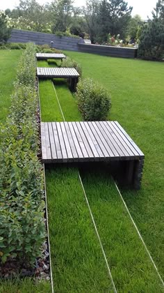 two wooden benches sitting on top of a lush green field