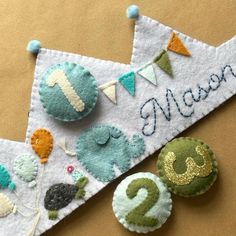 there are two buttons on top of a banner that says happy 2nd birthday with bunting and balloons