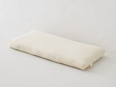 a white pillow sitting on top of a white floor