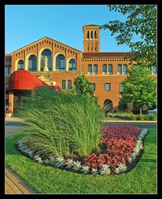 a building with a clock tower in the middle of it's front lawn area