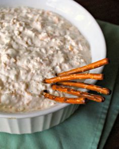 a white bowl filled with oatmeal and carrot sticks