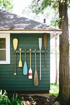 a green house with paddles and spoons hanging on the side of it's wall