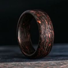 a wooden ring that is on top of a table with dark wood in the background