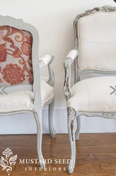 two white chairs sitting next to each other on top of a wooden floor