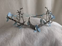 This gorgeous tiara features a filigree crescent moon, a sparkling opalescent blue crystal in the center, and branches on either side. Fallen sky blue leaves surround the flexible branch-like base. This piece is adjustable with a ribbon tie in the back. Choose between a silver moon and branches as pictured or bronze! Blue Adjustable Whimsical Headpiece, Whimsical Blue Adjustable Headpiece, Woodland Tiara, Magical Jewelry, Coron, Head Piece, Fantasy Dress, Fancy Jewelry, Fantasy Jewelry